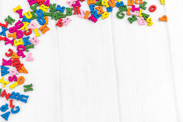 Multicolor letters on white wood background.