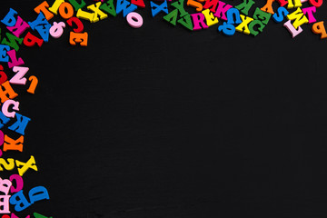 Multicolor letters on black wood background