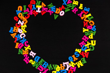 Letter in the form of hearts on black wood background