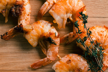 Five headless friend shrimps with thyme sprig on them
