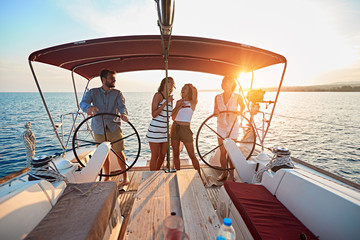 friends on vacation travel on boat together and enjoy at sunset.