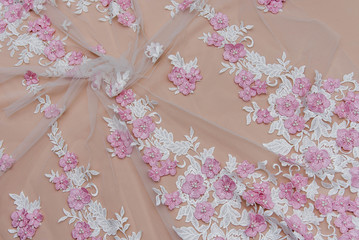 Texture lace fabric. lace on white background studio. thin fabric made of yarn or thread. a background image of ivory-colored lace cloth. White and rose lace on beige background.