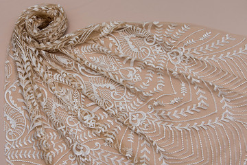 Texture lace fabric. lace on beige background studio. thin fabric made of yarn or thread. typically one of cotton or silk, made by looping, twisting, or knitting thread in patterns