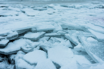 Shards of cracked ice on shore of frozen lake