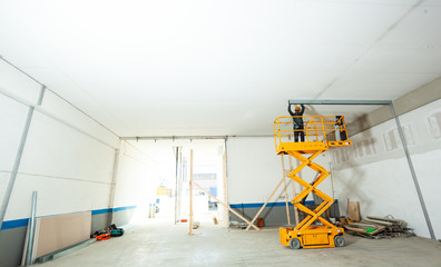 Worker builds a plasterboard wall.