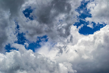 puffy clouds floating amongst a blue sky
