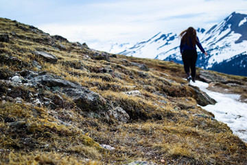 a woman hiking a sparse trail in the alpine tundra