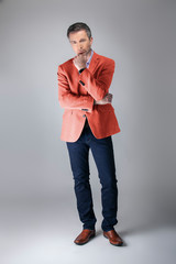 Middle-aged fashion model wearing coral colored sports coat or jacket for the fall clothing...