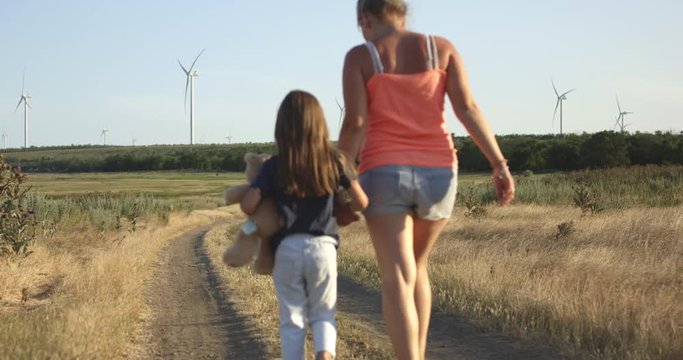 Mother and daughter walking on pathway