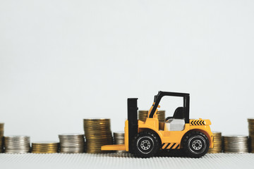 Mini forklift truck with coin stack, business finance and banking industrial concept.