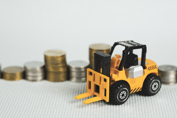 Mini forklift truck with coin stack, business finance and banking industrial concept.