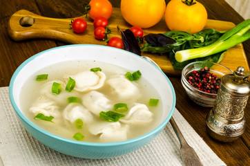 Hot broth with ravioli and green onions