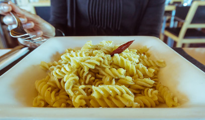 Plate of pasta twists presentation, in a square white plate. Ready  to eat.