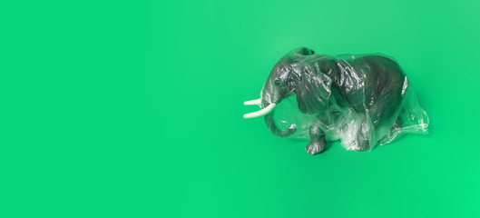 Elephant in plastic. The figure of a mammal is tangled in the package. Copy spase