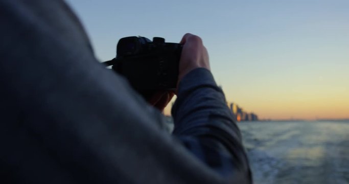Close Up of Male Model Photographing Beautiful Sunset and Beautiful Skyscrapers and Skyline In NYC On Hudson River Moving Away From Incredible New York Sunset