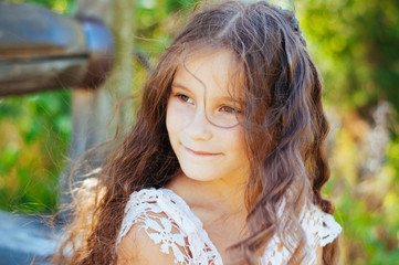 Emotional portrait of a little girl with long hair, summer day