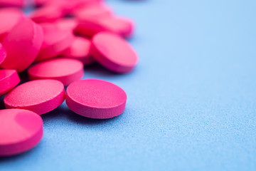 Obraz na płótnie Canvas pink pill on blue drugs medical