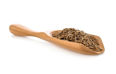 caraway seeds in wood scoop on white background