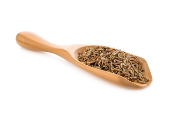 caraway seeds in wood scoop on white background