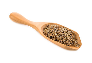 caraway seeds in wood scoop on white background