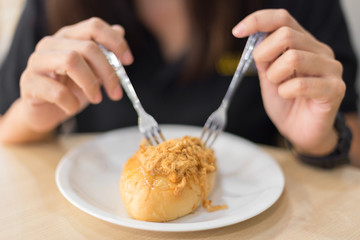 Woman eating bread in white plate