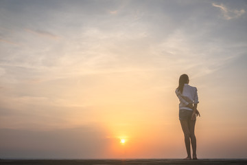 Fototapeta premium Silhouette of free woman enjoying freedom feeling happy at sunset. Serene relaxing woman in pure happiness