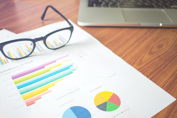 Office workplace with computer and eyeglasses on wood desk.