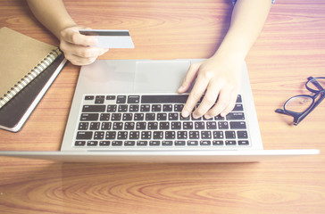 Top view, hand holding a credit card, key information to the computer. Online shopping