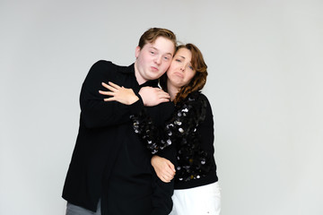 Portrait below the belt on a white background pretty young brunette woman in a black sweater and a young man in a black shirt. Standing in different poses, talking, showing emotions.