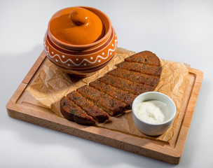 A Pot Of Soup With A Big Slice Of Black Bread And Sour Cream