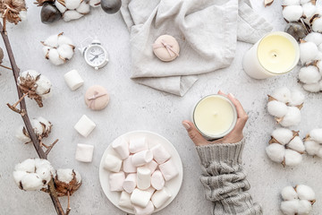 Female workspace in pastel tones. Marshmallows, cotton, candles top view on white marble background