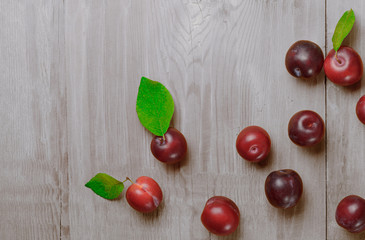 Plums on white wooden table. Top view.