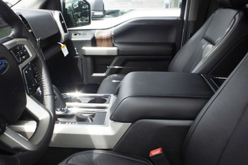 Interior shot of passenger and driver side of a new 2019 Ford F-150 LAriat at a car dealership in...