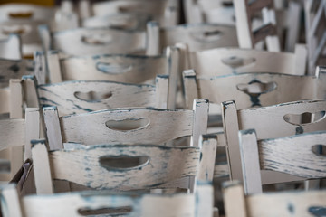 Row of empty white wooden chairs