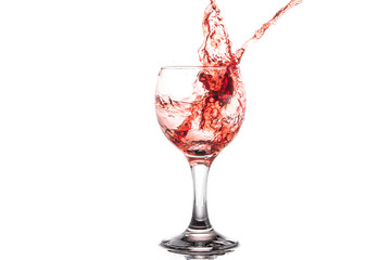 Red wine splash in a round glass on a white background