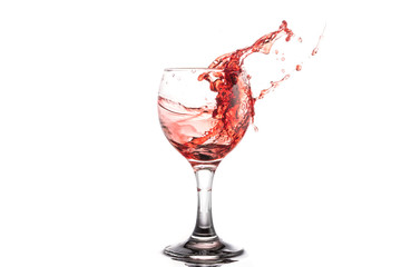 Red wine splash in a round glass on a white background