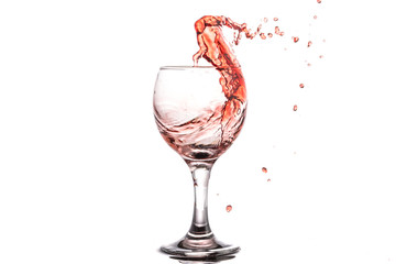 Red wine splash in a round glass on a white background