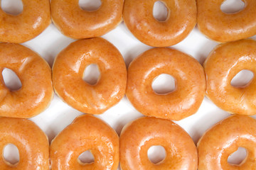 Top view flat lay close up of plain glazed donuts in a white box isolated. One dozen donuts. The...
