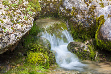 Fototapeta na wymiar Water runs over rocks in the mountains