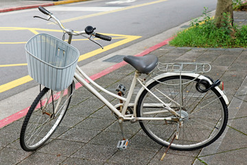 Fototapeta na wymiar Vintage White Bicycle Parking on the Pathway