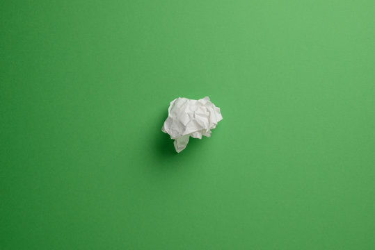 Papel arrugado sobre fondo liso de color verde