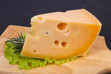 Maasdam cheese  in the board served salad leaves