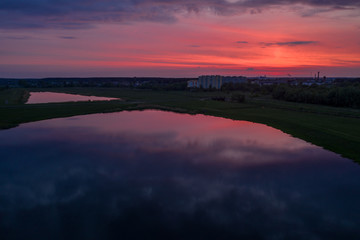 Fototapeta na wymiar Smooth lakes in the fields of Belarus on a beautiful crimson sunset