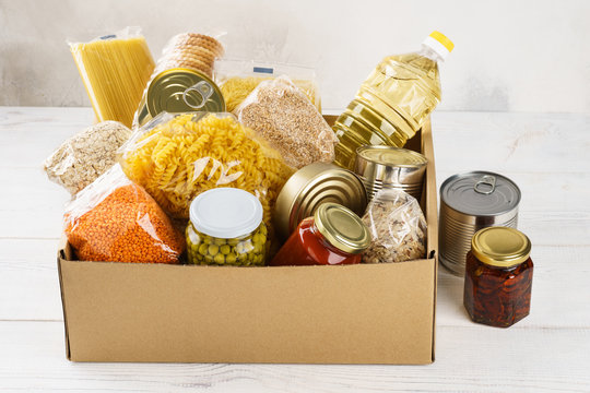 Various Canned Food, Pasta And Cereals In A Cardboard Box.