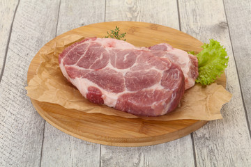 Raw pork steak over wooden board