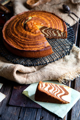 homemade baked striped cut cake zebra from childhood stands on wicker black stand