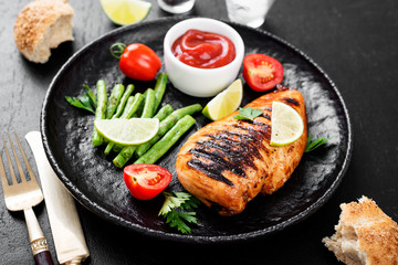 Grilled chicken breast with lemon and green beans . 