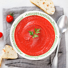Tomato soup in bowl on light grey stone background. Top view.