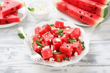 Summer salad of watermelon, feta cheese and mint leaves. on white wooden background