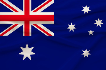 The national flag of the country of Australia on gentle silk with folds from the wind, the concept of travel, immigration, politics, copy space, close-up